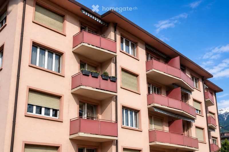 Multi-story residential building with pink balconies, large windows, and potted plants on one balcony. The building has a modern design with clean lines and a flat roof.