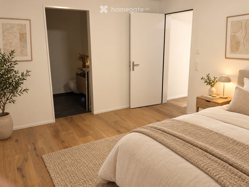 Modern bedroom with a large bed, nightstand, lamp, and potted plant. The room features wooden flooring and a partially visible bathroom with a toilet and sink.
