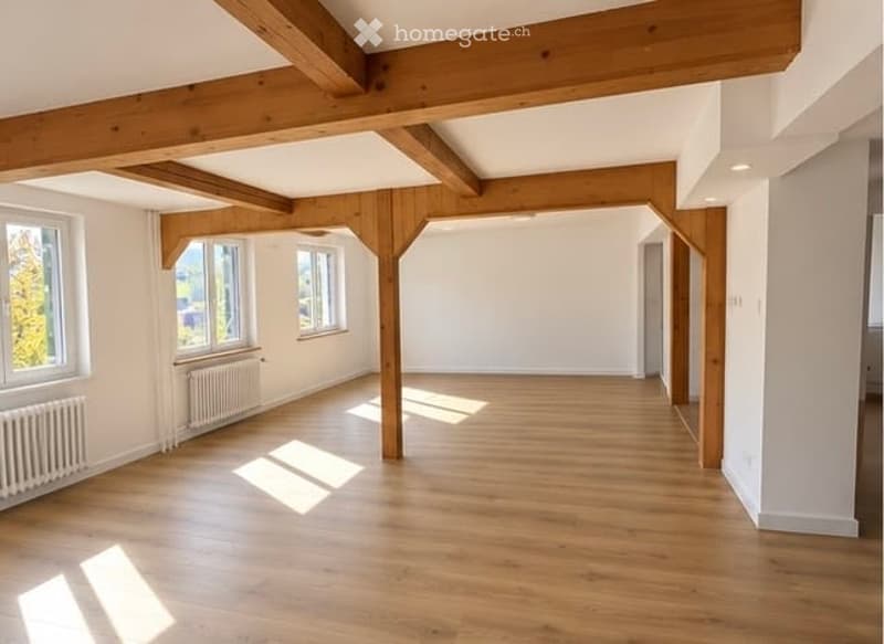 Bright, empty room with wooden flooring and exposed wooden beams on the ceiling. Large windows allow natural light to fill the space, and there is a radiator visible along one wall.