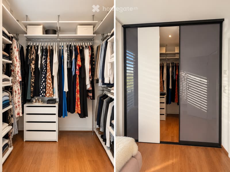A well-organized walk-in closet with wooden flooring, white walls, and multiple clothing racks, shelves, and drawers. A large mirrored sliding door provides access to the closet.
