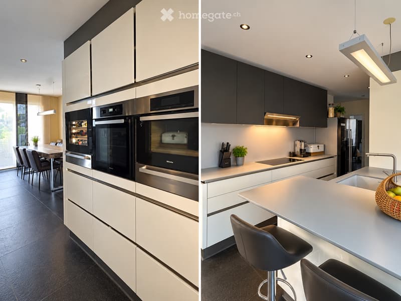 Modern kitchen with white and black cabinets, stainless steel appliances, island with bar stools, and a dining area with a table and chairs.
