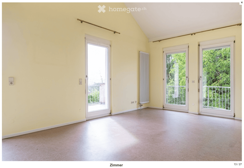Empty room with light yellow walls, white sliding doors leading to a balcony, and a radiator on one wall.