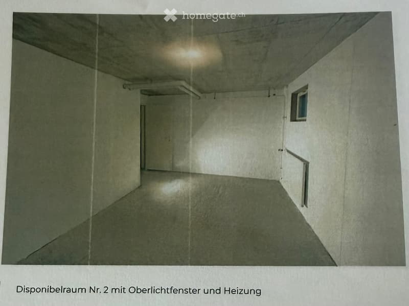 Empty room with concrete walls and floor, a small window, and a door leading to another space.