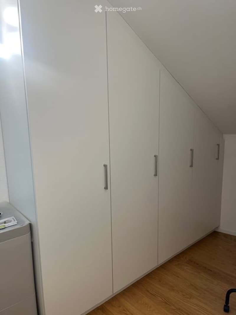 Empty room with white built-in wardrobes and wooden flooring. No furniture or equipment present.