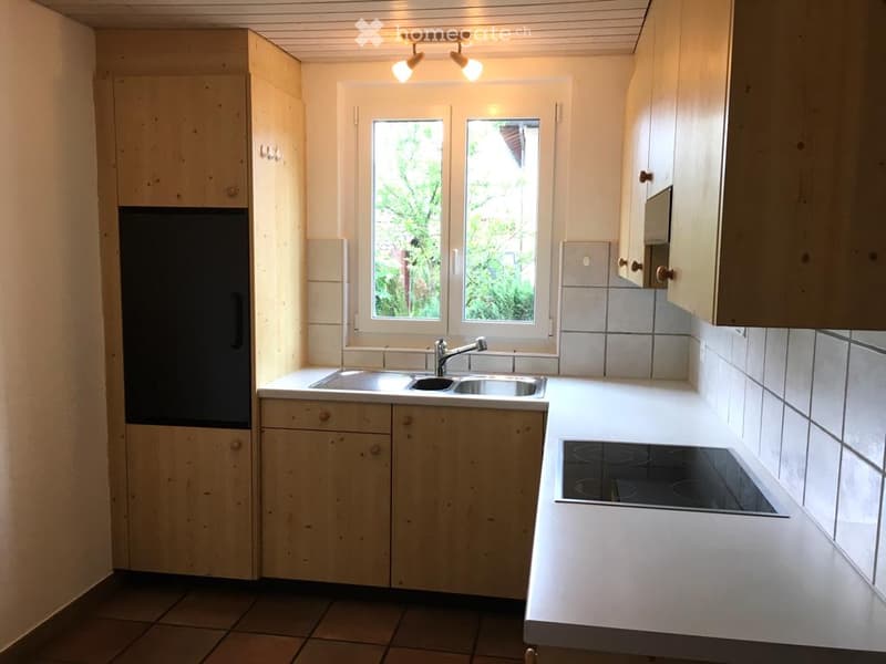 kitchen with appliances, wooden cabinets, double sink, electric stove, white tile
