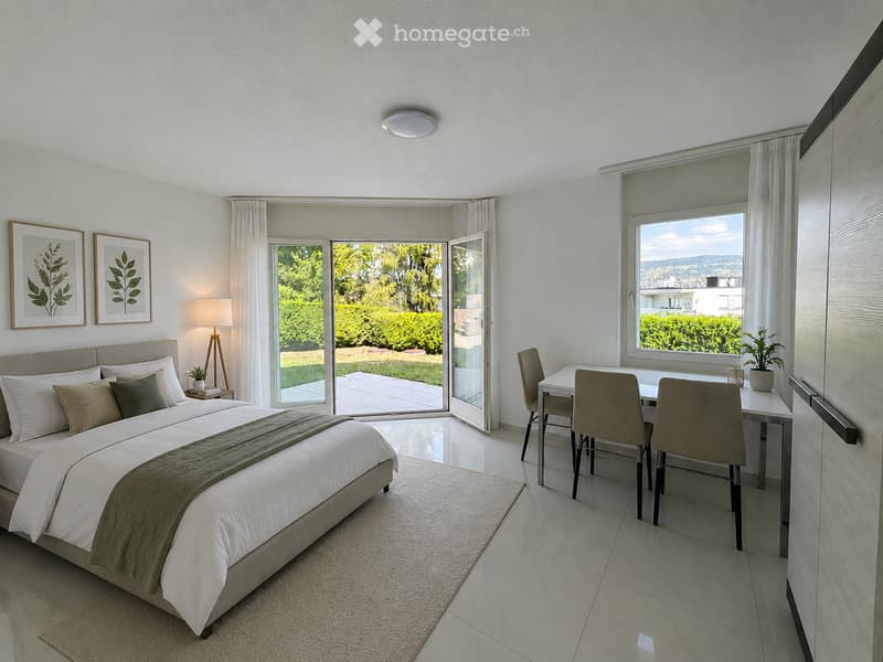 Modern bedroom with a large bed, nightstand, desk area with chairs, large windows, and a view of a garden.