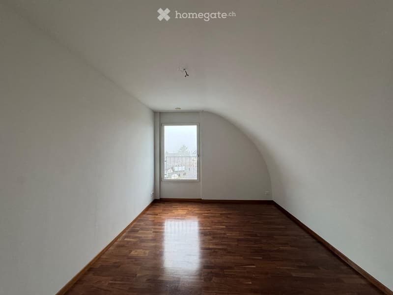 Empty room with wooden flooring, white walls, and a door leading to a balcony.