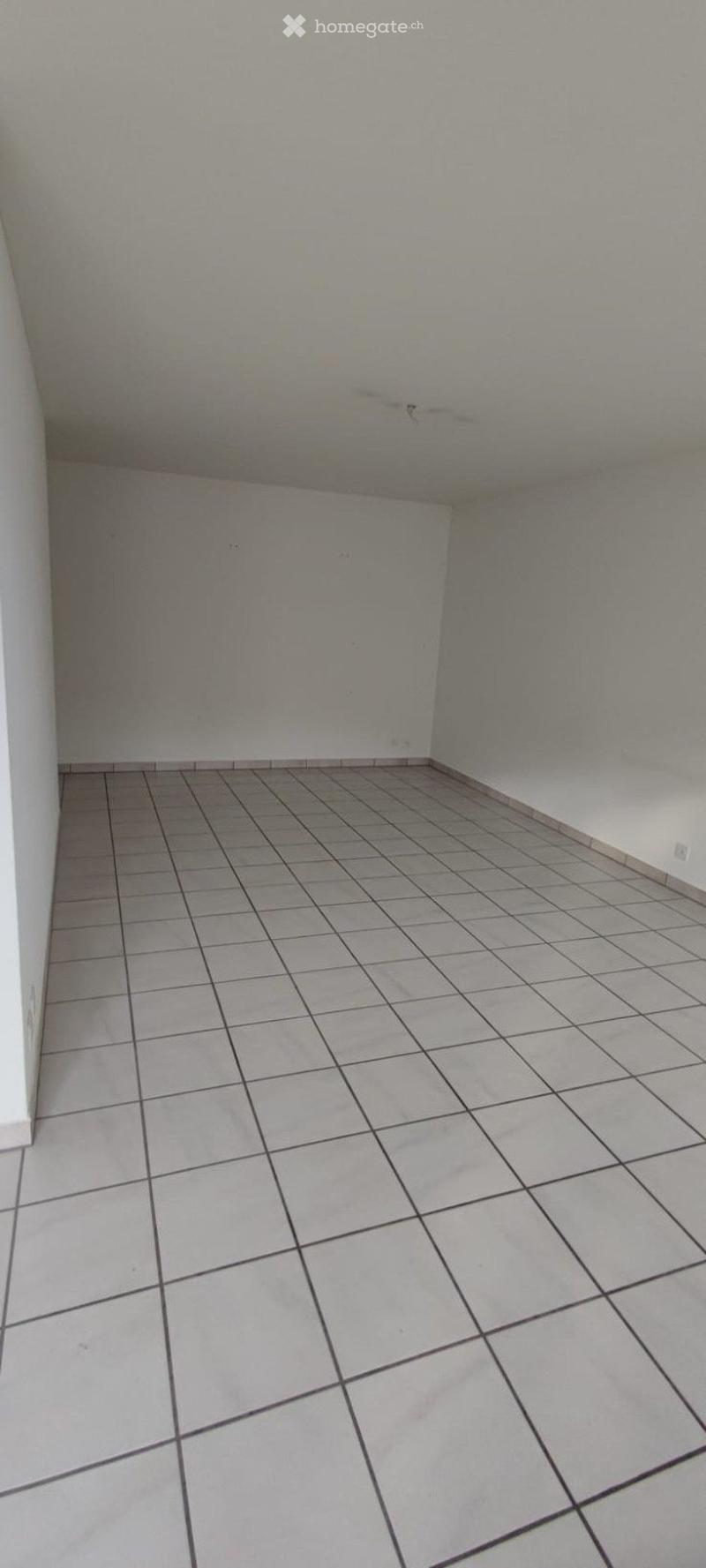 Empty room with tiled floor and white walls, no furniture or equipment.