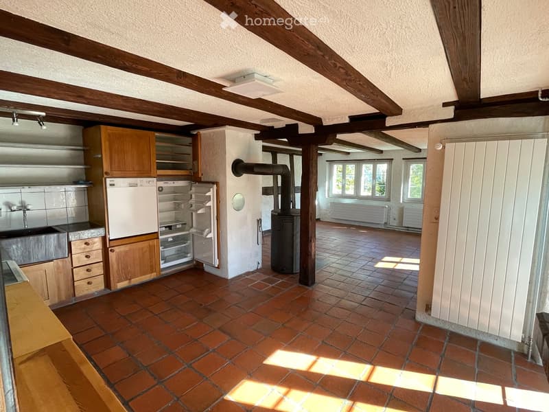 Kitchen with wooden beams, wooden floor, wooden ceiling, wooden door, wooden window, wooden radiator, wooden stove, refrigerator, sink, and cabinets.