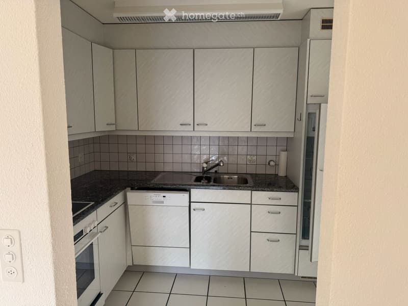 Modern kitchen with white cabinets, granite countertop, sink, faucet, oven, and dishwasher.