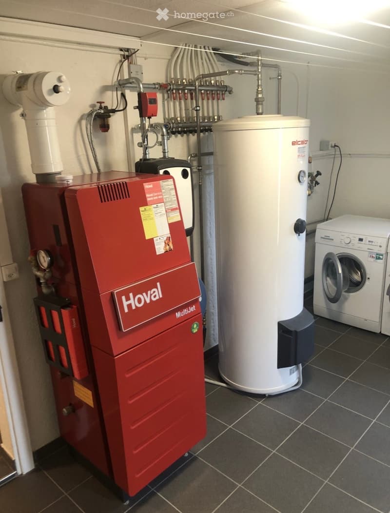 Utility room with a red Hoval MultiJet boiler, a white water heater, and a white washing machine.