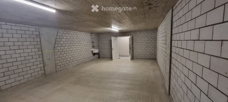 Empty room with concrete walls and floor, a single sink, and a doorway leading to another space.