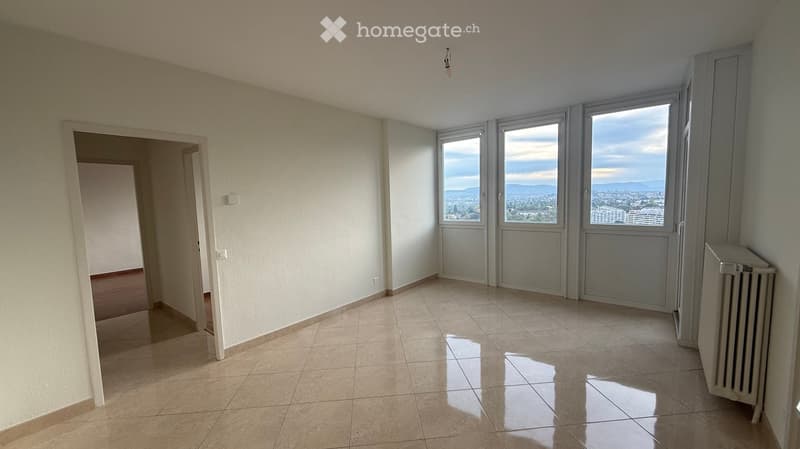 Empty room with tiled floor, large windows offering a scenic view, and a radiator on the wall.