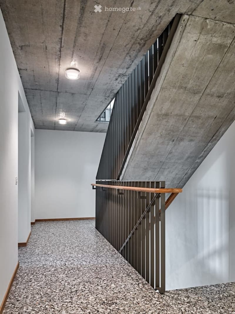 granite floor, two concrete wall, black railing, two lights on ceiling