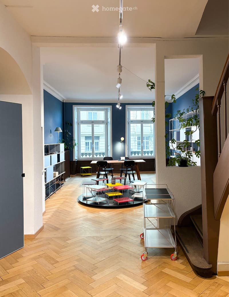 wooden parquet flooring, blue walls, modern seating and tables, brass pendant lights