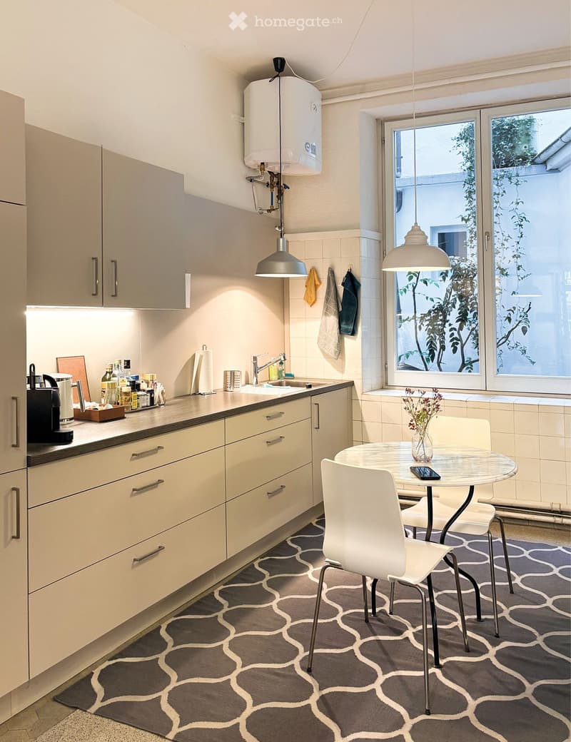 modern kitchen with marble countertop, sink, faucet, window, built-in cabinets, chairs, round table, cell phone, flowers