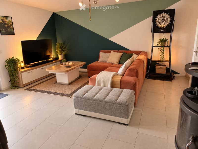 Modern living room with a sectional orange sofa, ottoman, coffee table, TV stand, floor lamp, side table, potted plants, and a dartboard on a shelf.