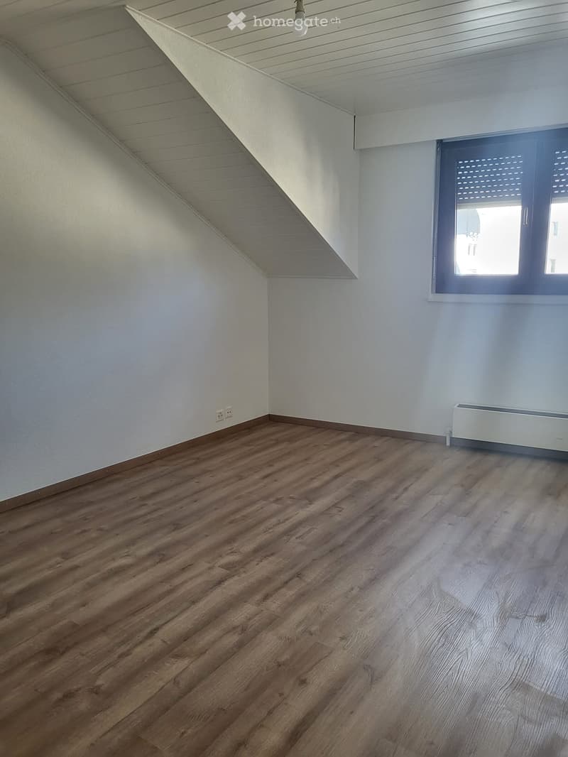 Empty room with wooden flooring, white walls, and a window with blinds. No furniture or equipment present.