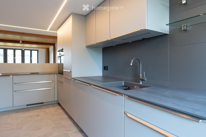 modern kitchen with a gray countertop, a sink, a faucet, white cabinetry, a glass shelf, and a wooden ceiling