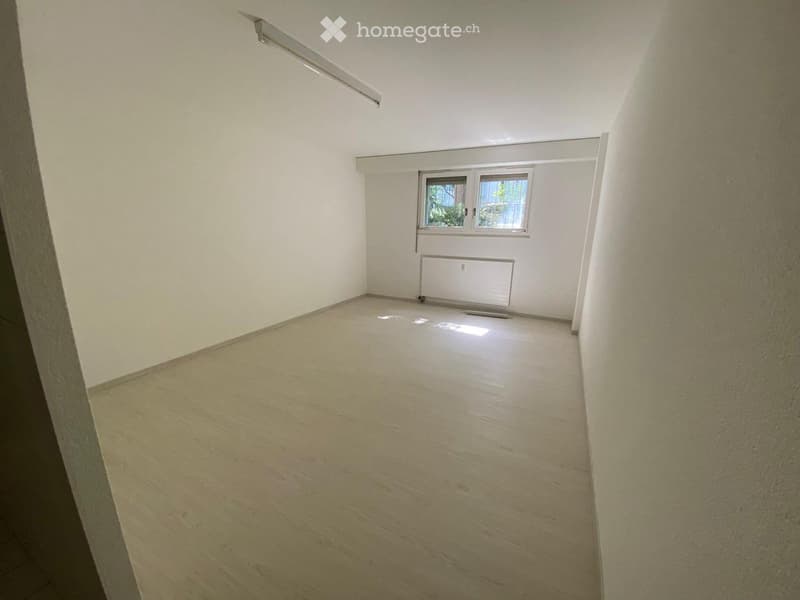 empty room with white walls, wooden floor, windows and electrical outlet