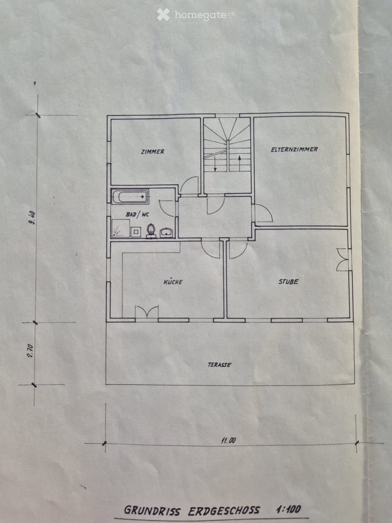 Floor plan of a ground floor showing a living room (Stube), kitchen (Küche), bedroom (Zimmer), parent's room (Elternzimmer), bathroom (Bad/WC), and terrace (Terrasse).