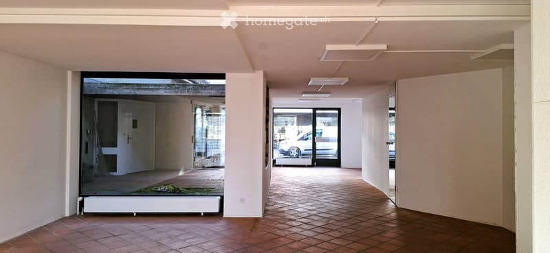 empty hallway, terracotta tiles, large windows, sliding glass door, white walls, lights on ceiling
