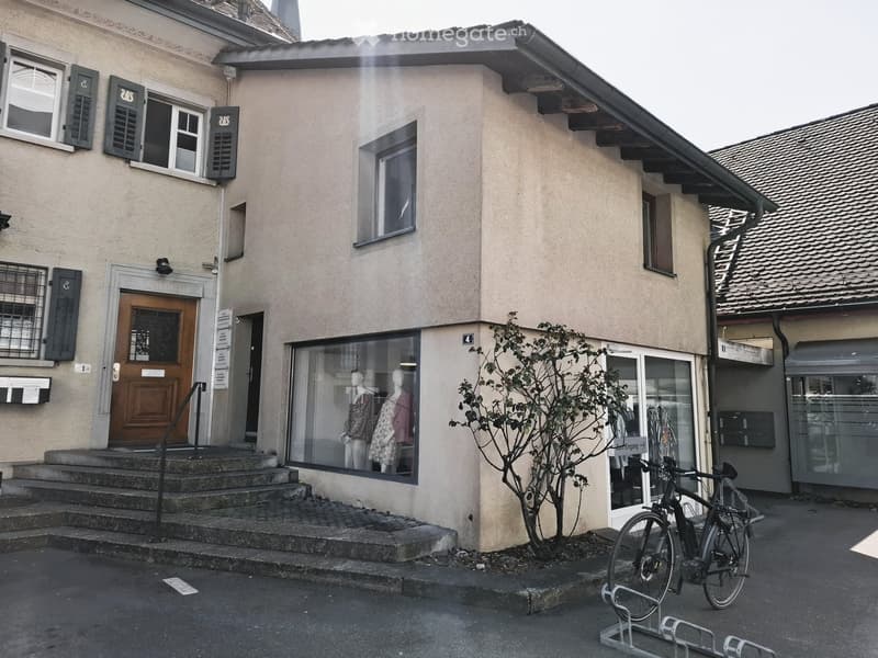 Facade with 3 windows, wooden door, 4 steps leading to entrance, bicycle parking