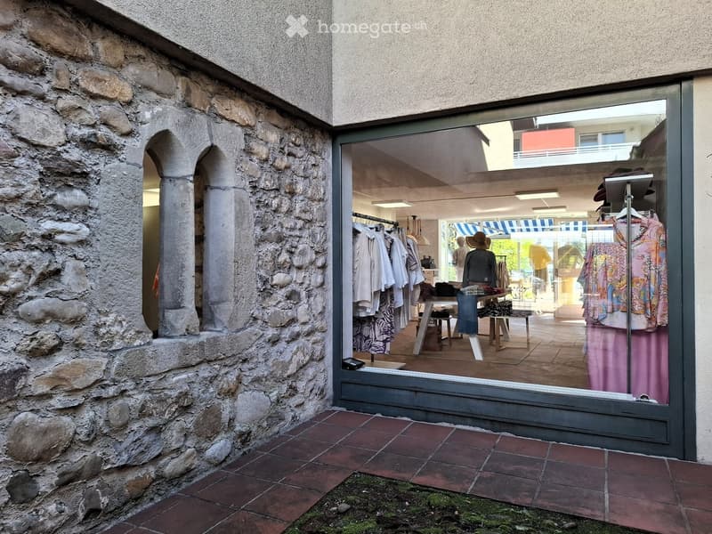 Stone wall, metal framed glass door, clothing displays