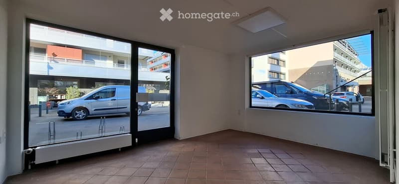 empty room with glass walls, ceramic floor, visible radiators, bright light