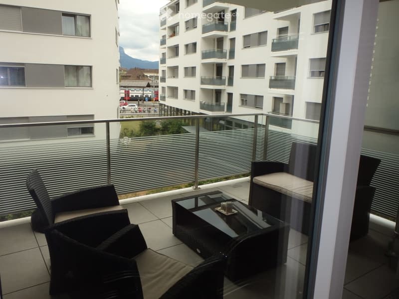 Balcony with table and chairs, view to the street and mountains