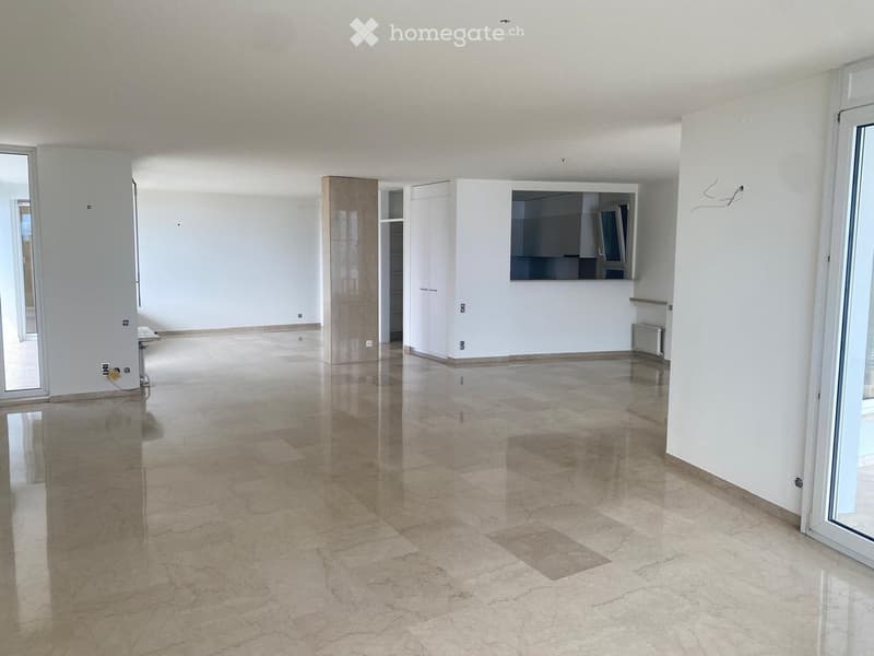 Empty room with polished marble floors, white walls, and large windows. No furniture or equipment present.