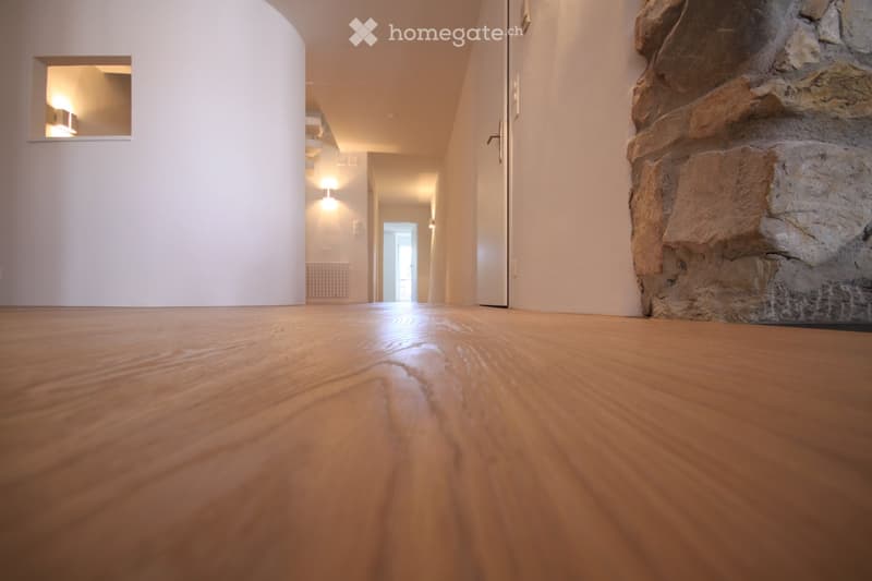 wooden floor, white walls, hallway, recessed lighting, stone pillar