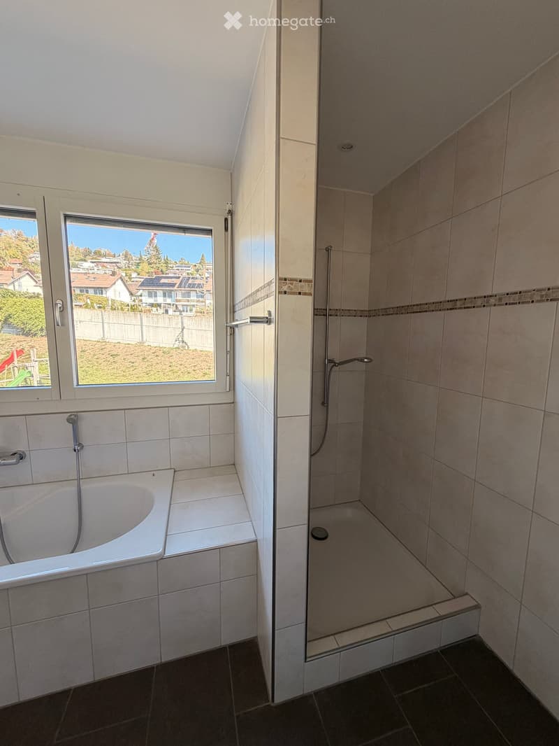 Bathroom with a bathtub on the left and a walk-in shower on the right, both with modern tilework and fixtures.