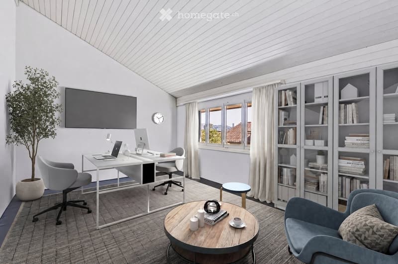Modern, well-lit room with a slanted ceiling, featuring a desk with a laptop, a comfortable chair, a bookshelf filled with books, a round coffee table with a cup and decorative items, and a large screen mounted on the wall.