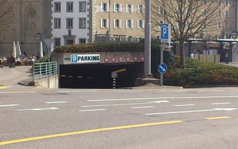 Underground parking entrance with a sign reading "PARKING" and a small landscaped area above it.
