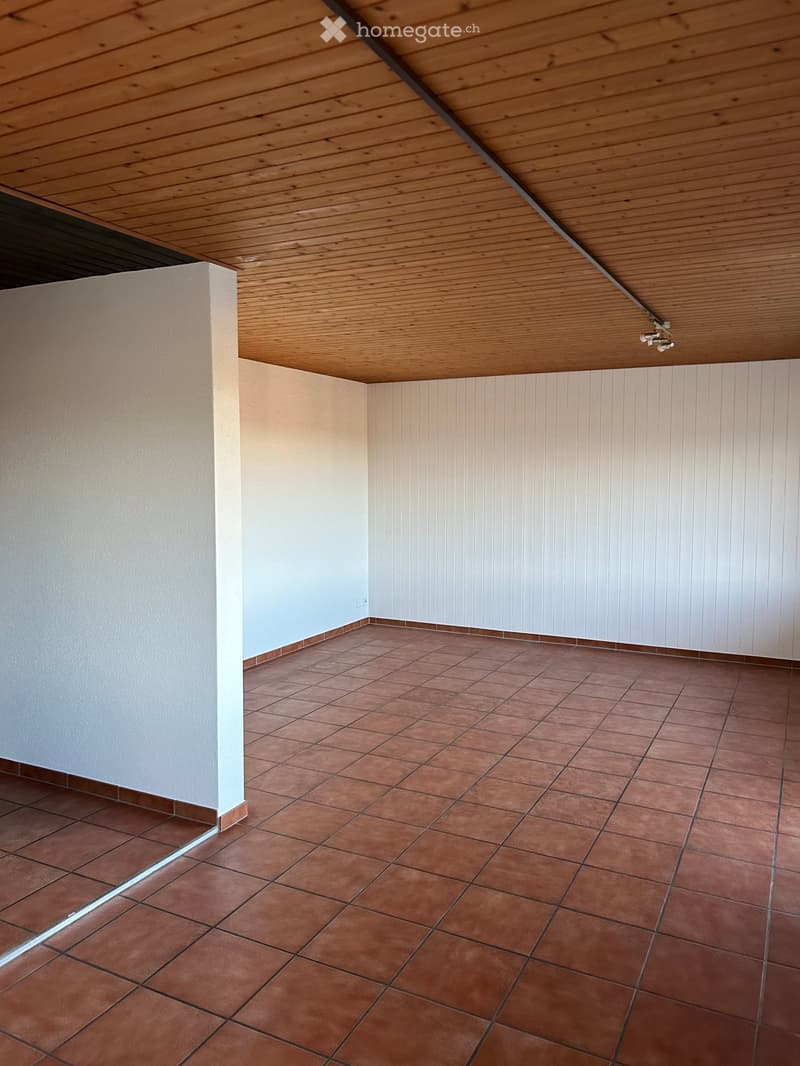 Empty room with wooden ceiling, tiled floor, and white walls. No furniture or equipment present.