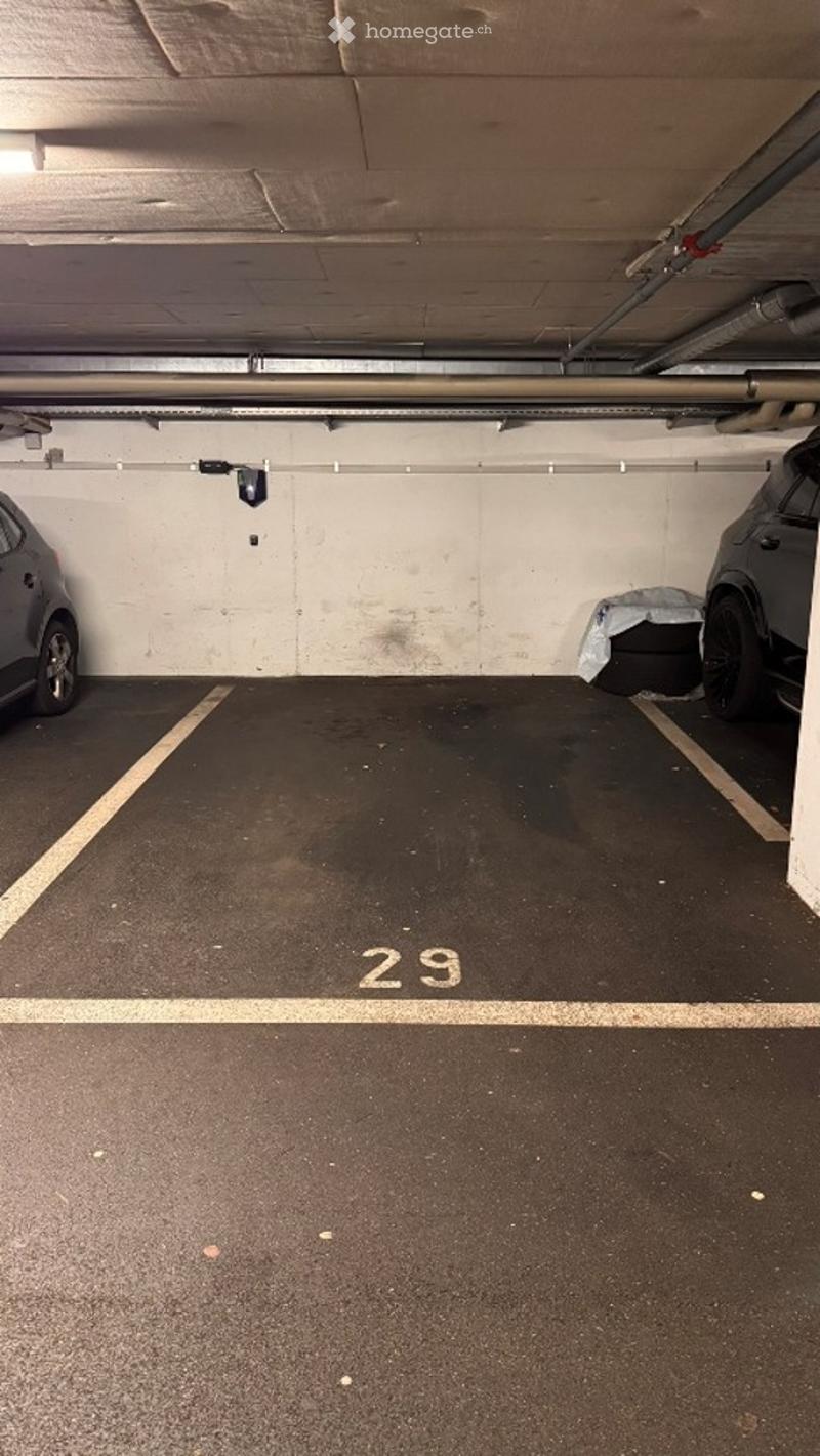 Underground parking space with marked parking spots, two cars partially visible, and a numbered spot labeled '29'.