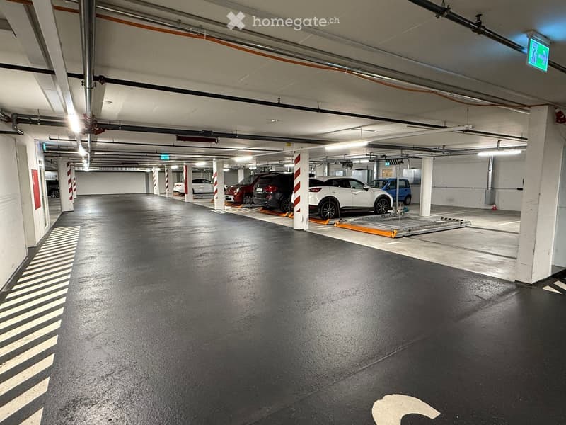 underground parking area with 5 parked cars and designated parking spots