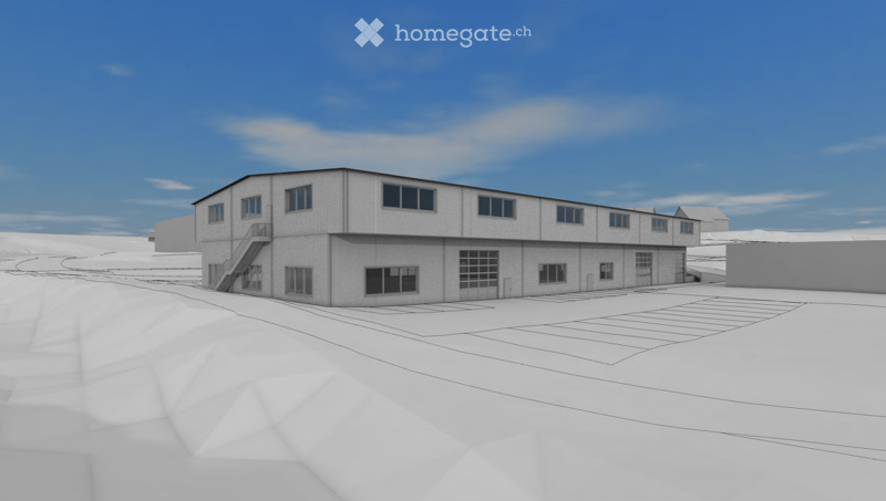 A modern, single-story industrial or commercial building with a flat roof, large windows, and a central entrance. The structure is surrounded by open space with a clear blue sky in the background.