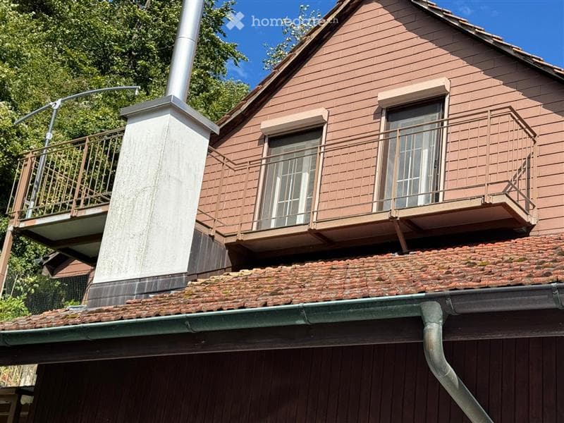 chimney, terrace with iron railing, two windows