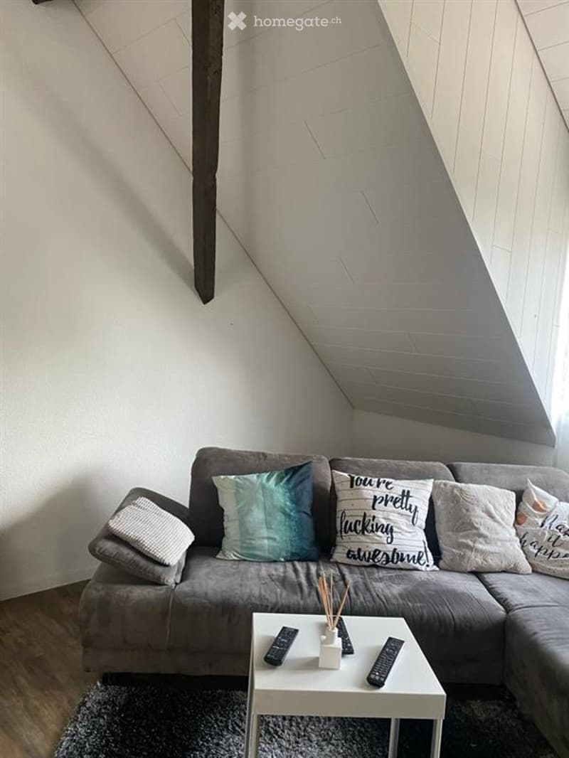 living room, attic couch, L-shaped couch, remotes on coffee table, pillows