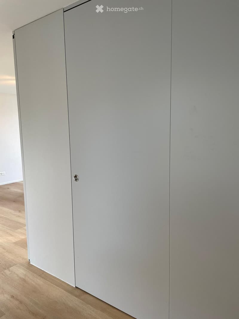 Empty room with light-colored wooden flooring and white walls. No furniture or equipment visible.