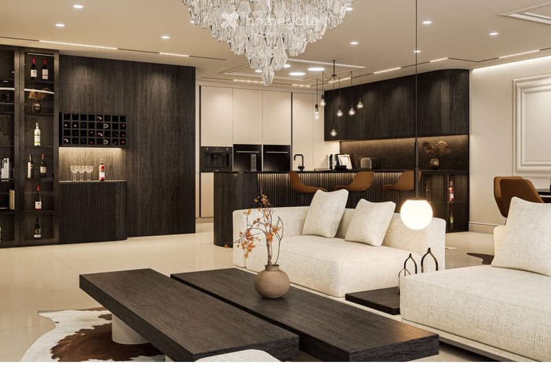 Modern living room with a white sofa, dark wooden coffee table, wine rack, bar counter with stools, and a chandelier.