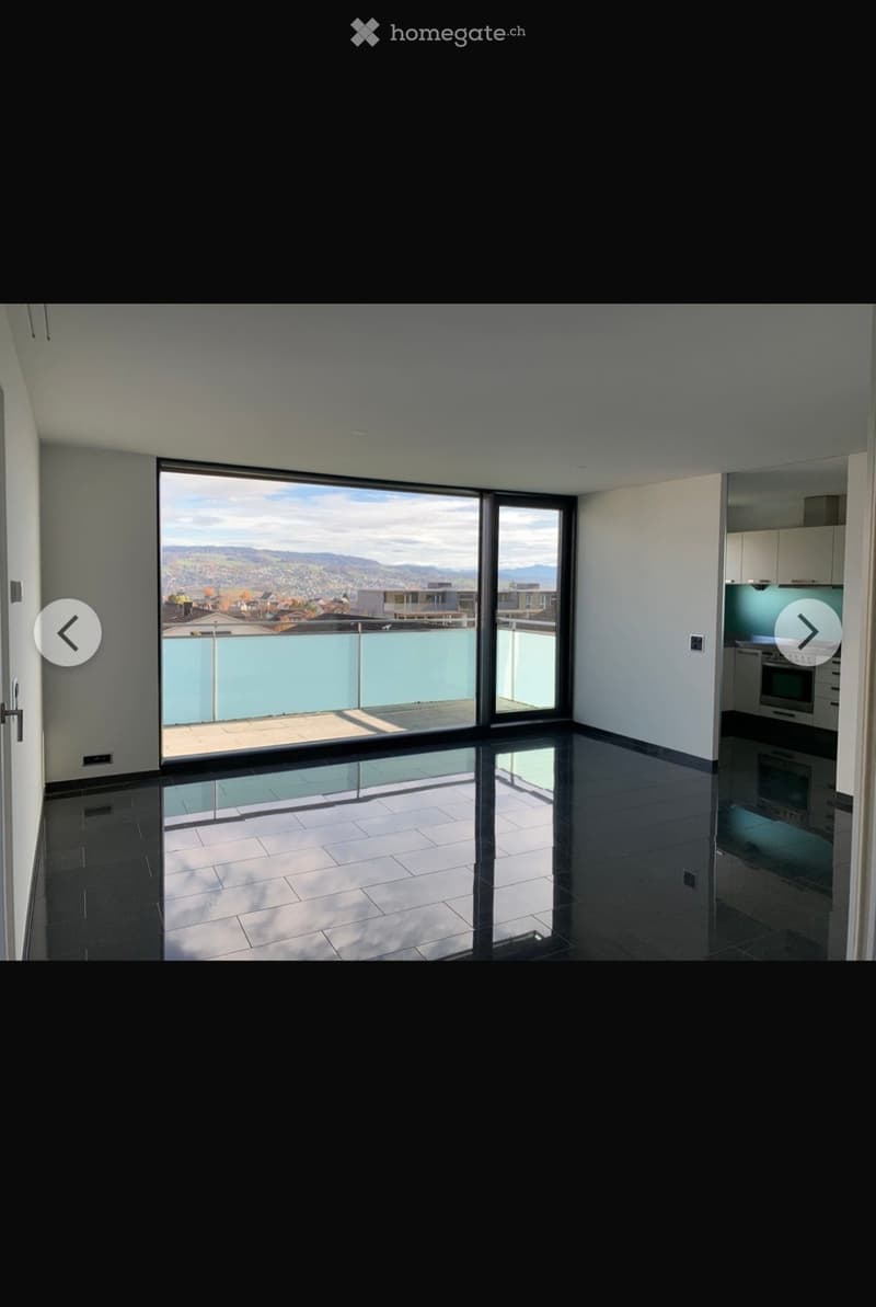 Modern kitchen with dark tiled floor, large window offering a scenic view, and built-in oven.