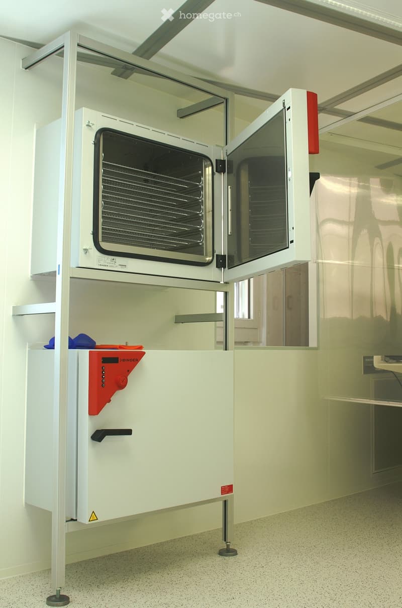 A kitchen area with a built-in oven and microwave, white cabinets, and a control panel.