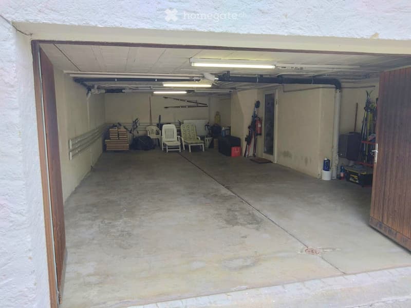 {"type": "Garage", "objects": ["chair", "stool", "ski", "snowboard", "fire extinguisher", "storage box"], "description": "Garage with concrete floor, exposed pipes, and storage items including chairs, skis, and a fire extinguisher.", "visible_features": [