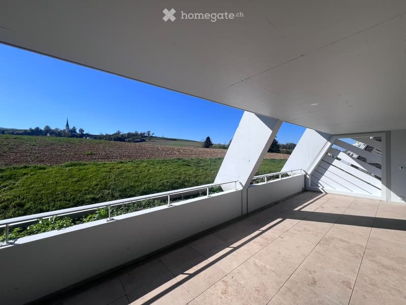 Modern balcony with white railings, tiled floor, and scenic countryside view.