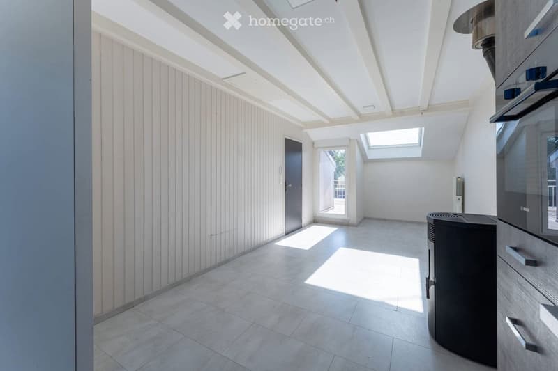 Bright, modern kitchen with white walls, tiled floor, and large windows allowing natural light. Features include an oven, built-in cabinets, and a sleek design.
