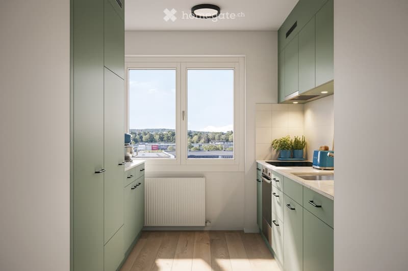 Modern kitchen with light green cabinets, wooden flooring, and large windows offering a view of greenery. Features include a sink, oven, toaster, and potted plants on the counter.