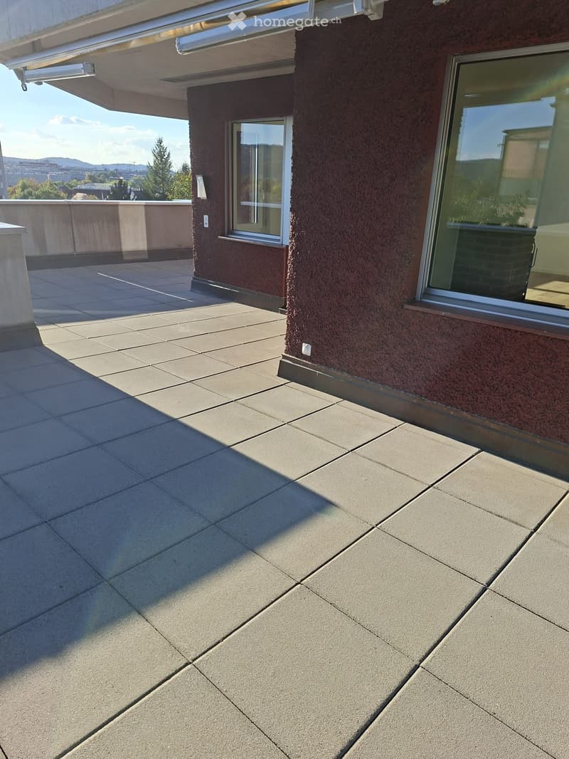 Balcony with tiled floor, large windows, and a view of the surrounding area.